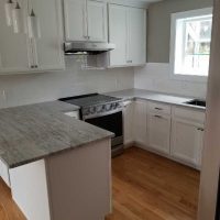 View into kitchen with updated lighting fixtures and flooring